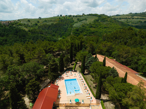 Vista aérea de Camping Pian Di Boccio en Umbría, Italia, con piscina y colinas verdes alrededor del parque.