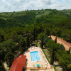 Aerial view of Camping Pian Di Boccio holiday park in Umbria, Italy, featuring a pool and forested hills.