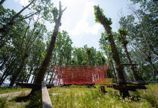 Parco avventura con percorsi tra reti e alberi al Camping Punta Navaccia, villaggio vacanze in Umbria, Italia.