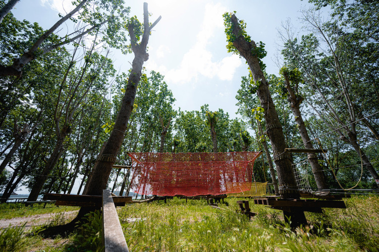 Abenteuerpark Kletterparcours mit Netzen und Bäumen im Camping Punta Navaccia Ferienpark, Umbrien, Italien.