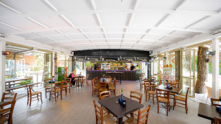 Cafetería luminosa y espaciosa con sillas y mesas de madera en Camping Punta Navaccia en Umbría, Italia.