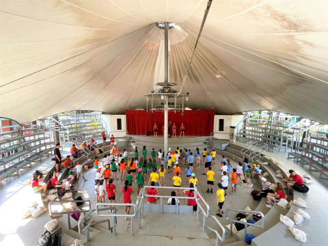 Niños participan en una actividad en el anfiteatro cubierto de Camping Punta Navaccia en Umbría, Italia.