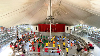 Niños participan en una actividad en el anfiteatro cubierto de Camping Punta Navaccia en Umbría, Italia.