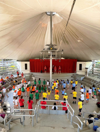 Børn deltager i en aktivitet under et overdækket amfiteater i Camping Punta Navaccia i Umbrien, Italien.