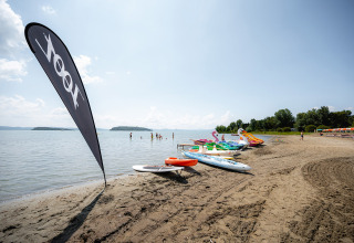 Strand met waterfietsen en paddleboards bij Camping Punta Navaccia, Umbrië, Italië, op een zonnige dag.