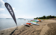 Plage au Camping Punta Navaccia, Ombrie, Italie, avec pédalos et paddle boards sous le soleil d'été.