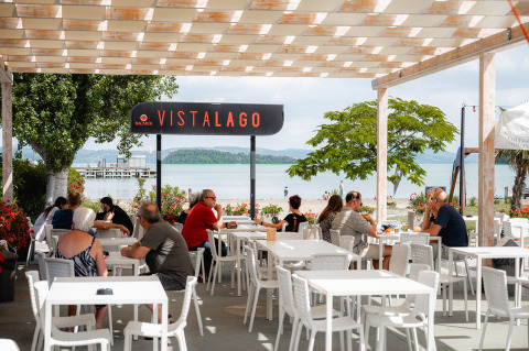 Udsigt over søen fra en udendørs restaurant på Camping Punta Navaccia feriepark i Umbrien, Italien.