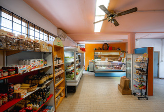 Supermarkt bij Camping Punta Navaccia in Umbrië, Italië met rekken vol etenswaren en verse producten.