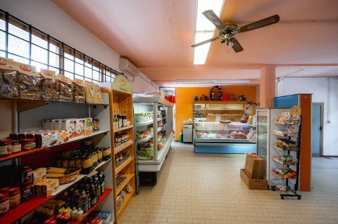 Supermarkt bij Camping Punta Navaccia in Umbrië, Italië, met schappen vol voedsel en gekoelde producten.