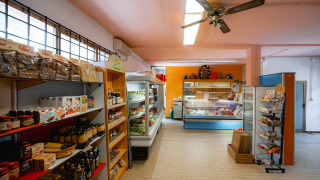 Tienda de comestibles en Camping Punta Navaccia, Umbría, Italia, con estantes de comida y productos frescos.