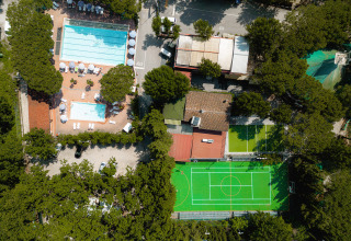 Vista aerea di Camping Punta Navaccia in Umbria, Italia, con piscine, campi sportivi e alberi.