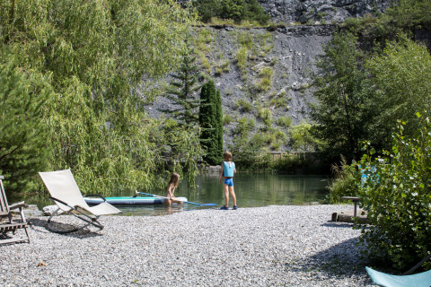 Dos niños juegan junto al río con tumbonas en Camping River, Provenza-Alpes-Costa Azul, Francia.