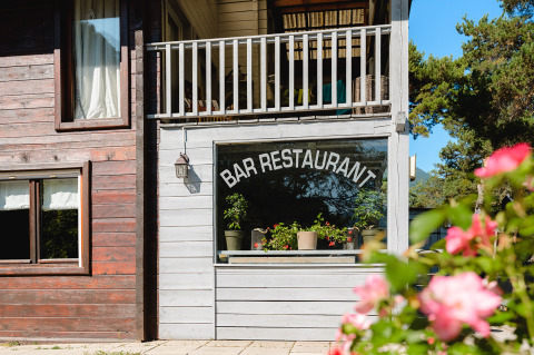 Facade af Bar Restaurant ved Camping River med blomster og træer i Provence-Alpes-Côte d’Azur, Frankrig.