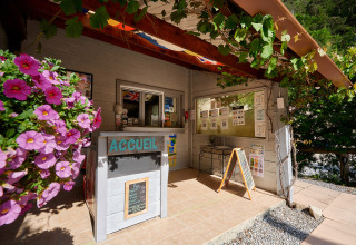 Receptie bij Camping River vakantiepark in Provence-Alpes-Côte d’Azur, Frankrijk, met bloemen en borden.