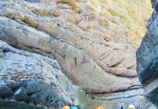 Gruppo che fa rafting tra gole rocciose con giubbotti salvagente al Camping River in Provenza-Alpi-Costa Azzurra, Francia.