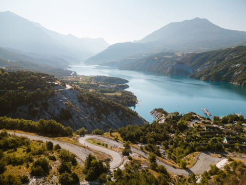 Vista panorámica de Camping River, un parque vacacional en Provenza-Alpes-Costa Azul, Francia, con lago y montañas.