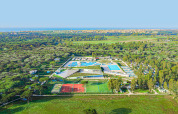 Vista aerea del Camping Roma Capitol nel Lazio, Italia, con piscine e campi sportivi tra aree verdi.