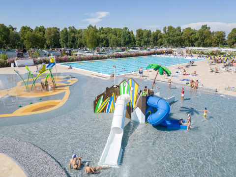 Piscina con toboganes y zona de juegos infantiles en Camping Roma Capitol, un parque vacacional en Lacio, Italia.