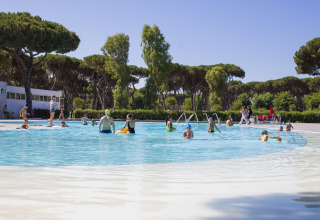Des familles se détendent dans la piscine extérieure du Camping Roma Capitol en Lazio, Italie, sous le soleil.