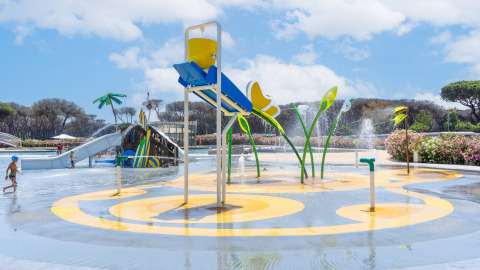 Parco giochi d’acqua per bambini al Camping Roma Capitol nel Lazio, Italia, con scivoli e spruzzi d’acqua.