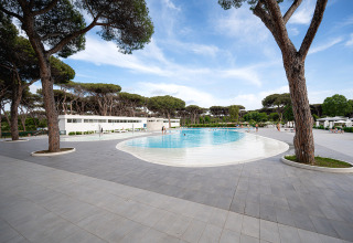 Zwembad in Camping Roma Capitol vakantiepark, omringd door bomen en moderne voorzieningen in Lazio, Italië.