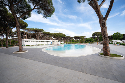 Swimming pool at Camping Roma Capitol holiday park, surrounded by trees and modern amenities in Lazio, Italy.
