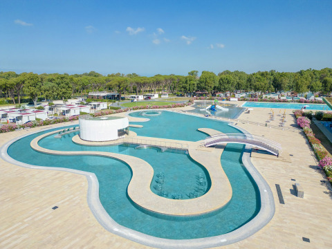 Grande piscina con ponti e servizi moderni presso il Camping Roma Capitol, un villaggio turistico nel Lazio, Italia.