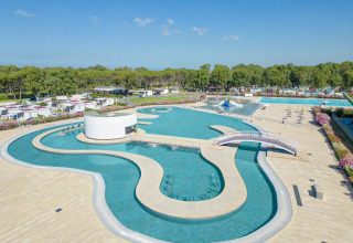 Large swimming pool with bridges and modern amenities at Camping Roma Capitol holiday park in Lazio, Italy.
