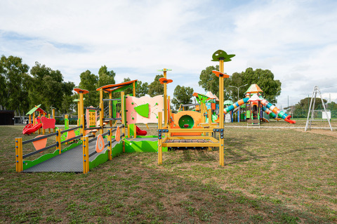 Parque infantil con equipos coloridos y tobogán en Camping Roma Capitol, parque vacacional en Lacio, Italia.