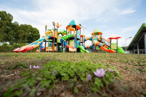 Farbiger Kinderspielplatz mit Rutschen und Türmen im Camping Roma Capitol, Lazio, Italien, aus Bodenperspektive.
