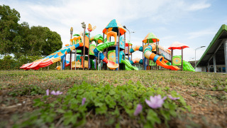 Colorido parque infantil con toboganes y torres en Camping Roma Capitol en Lacio, Italia, visto a nivel del suelo.