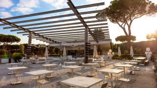 Zona de comedor al aire libre con mesas y sillas modernas en Camping Roma Capitol, parque vacacional en Lazio.