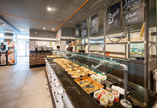 Area buffet al Camping Roma Capitol nel Lazio, Italia, con cibi, bevande e un’atmosfera accogliente.