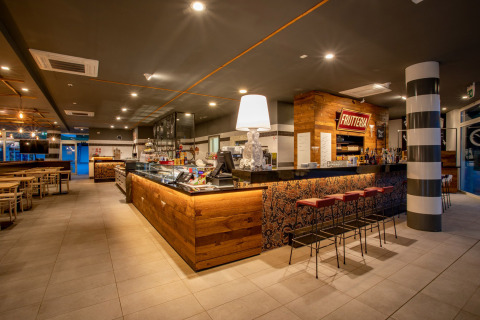 Modern bar and restaurant area at Camping Roma Capitol holiday park in Lazio, Italy, warmly lit.