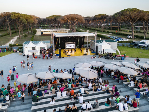 Open-Air-Aufführung im Camping Roma Capitol, Lazio, Italien, mit Zuschauern auf Sitzreihen.