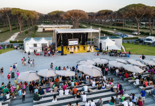Outdoor performance at Camping Roma Capitol holiday park, Lazio, Italy, with audience seated on benches.