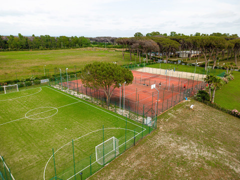 Vista aerea delle strutture sportive con campo da calcio e campi da tennis al Camping Roma Capitol, Lazio, Italia.