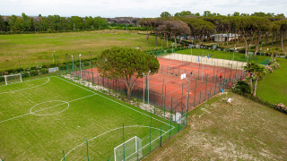 Vista aérea de instalaciones deportivas con campo de fútbol y canchas de tenis en Camping Roma Capitol, Lacio, Italia.