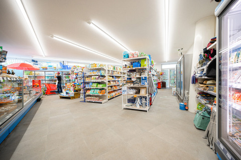 Supermercado con estantes llenos y refrigeradores en Camping Roma Capitol, un punto destacado en Lazio, Italia.