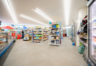 Supermarkt met gevulde schappen en koelingen bij Camping Roma Capitol, hoogtepunt in Lazio, Italië.