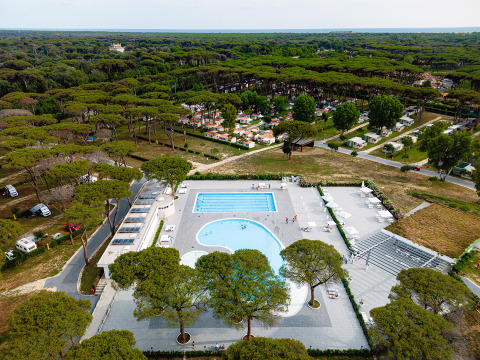 Vista aerea di Camping Roma Capitol nel Lazio, Italia, immerso nei pini con piscina e case mobili.