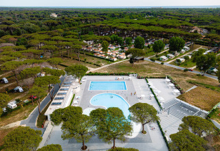 Vue aérienne du Camping Roma Capitol dans le Latium, Italie, avec piscines et nombreux pins verts.