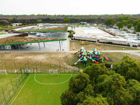 Vista aérea de Camping Roma Capitol en Lacio, Italia, con parque infantil, campo de fútbol y piscina.