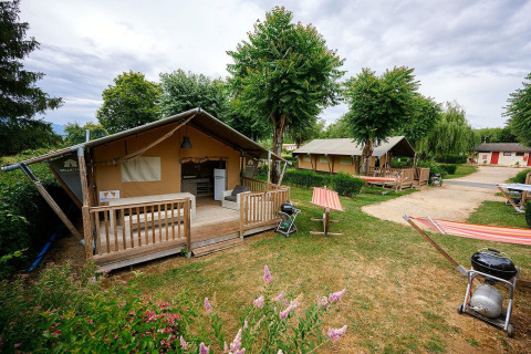 Tiendas safari en Villatent Nomad, Camping Le Coin Tranquille en Francia, con terrazas y zona verde.