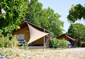 Safaritent Villatent Nomad op Camping Les Bois du Bardelet in Frankrijk tussen groene bomen en natuur.