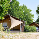 Safari teltet Villatent Nomad ved Camping Les Bois du Bardelet i Frankrig, omgivet af grønne træer.