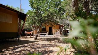 Safaritent Villatent Nomad op Camping Leï Suves in Frankrijk, omringd door bomen en natuur.