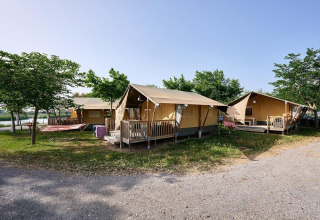 Tende safari Villatent Wood al Camping Nautic Almata in Spagna con verande e area ombreggiata da alberi.