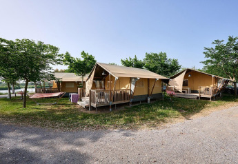Safari-telte Villatent Wood på Camping Nautic Almata i Spanien med verandaer og grønne omgivelser.