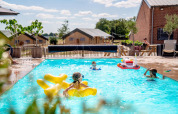 Børn leger i swimmingpoolen på FarmCamps Hoeve Luyterheyde, en feriepark i Nord-Brabant, Holland.